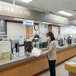 차량등록사업소 창구에서 명의이전 서류 제출하는 장면