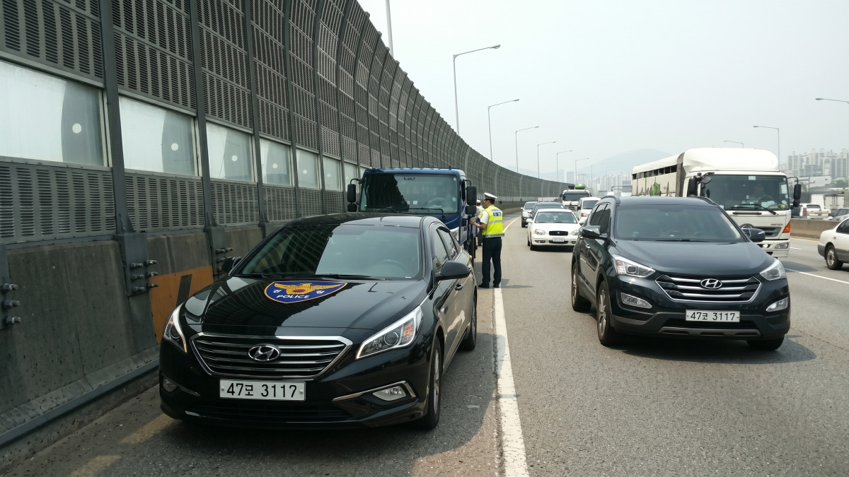 고속도로 갓길에서 암행순찰차가 차량을 단속하는 장면