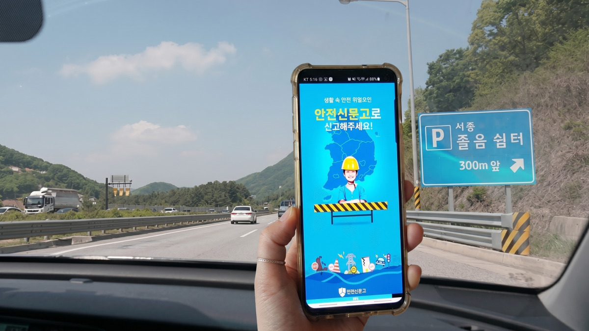 스마트폰으로 안전신문고 앱을 열어 신고하는 모습