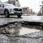 비 오는 도로 위 깊게 패인 포트홀 클로즈업